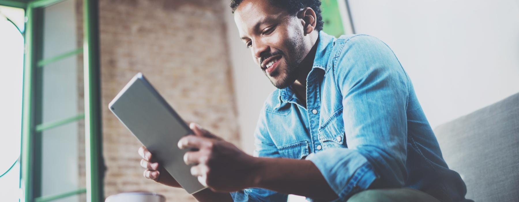 a man sitting on a couch holding a laptop